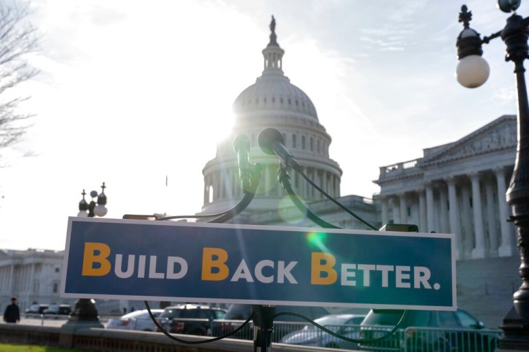 With the US Capitol dome in the background, a sign that reads 'Build Back Better' is displayed before a news conference