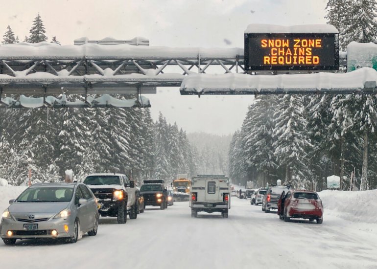 Heavy traffic is seen at the base of a snowy Santiam Pass in Detroit, Oregon, Sunday, Dec. 26, 2021.