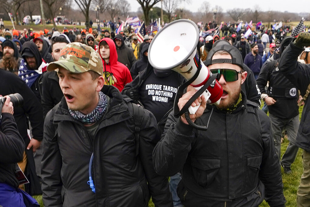 Os membros do Proud Boys, Zachary Rehl, à esquerda, e Ethan Nordean, com um megafone de mão, caminham em direção ao Capitólio dos Estados Unidos em Washington, em apoio ao presidente Donald Trump em 6 de janeiro
