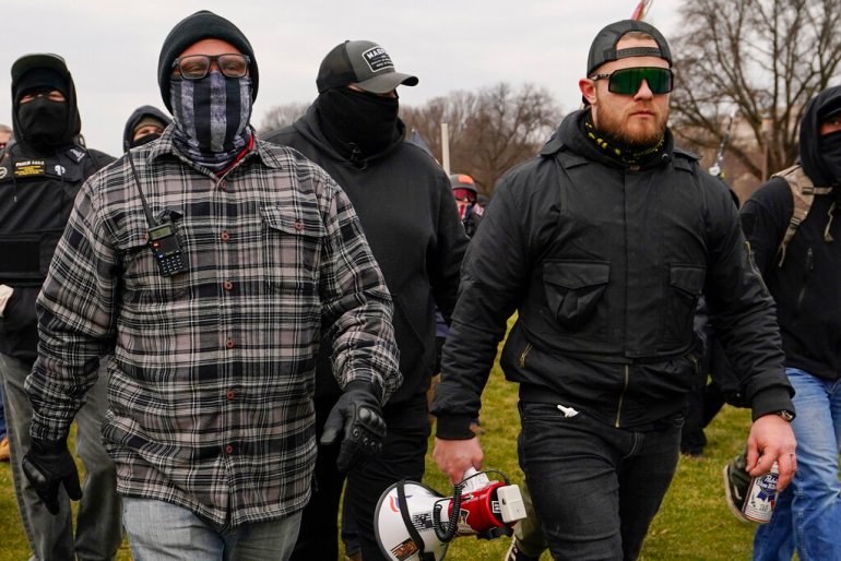 Proud Boys members Joseph Biggs, left with face mask, and Ethan Nordean, right with megaphone, walk toward the US Capitol on January. 6