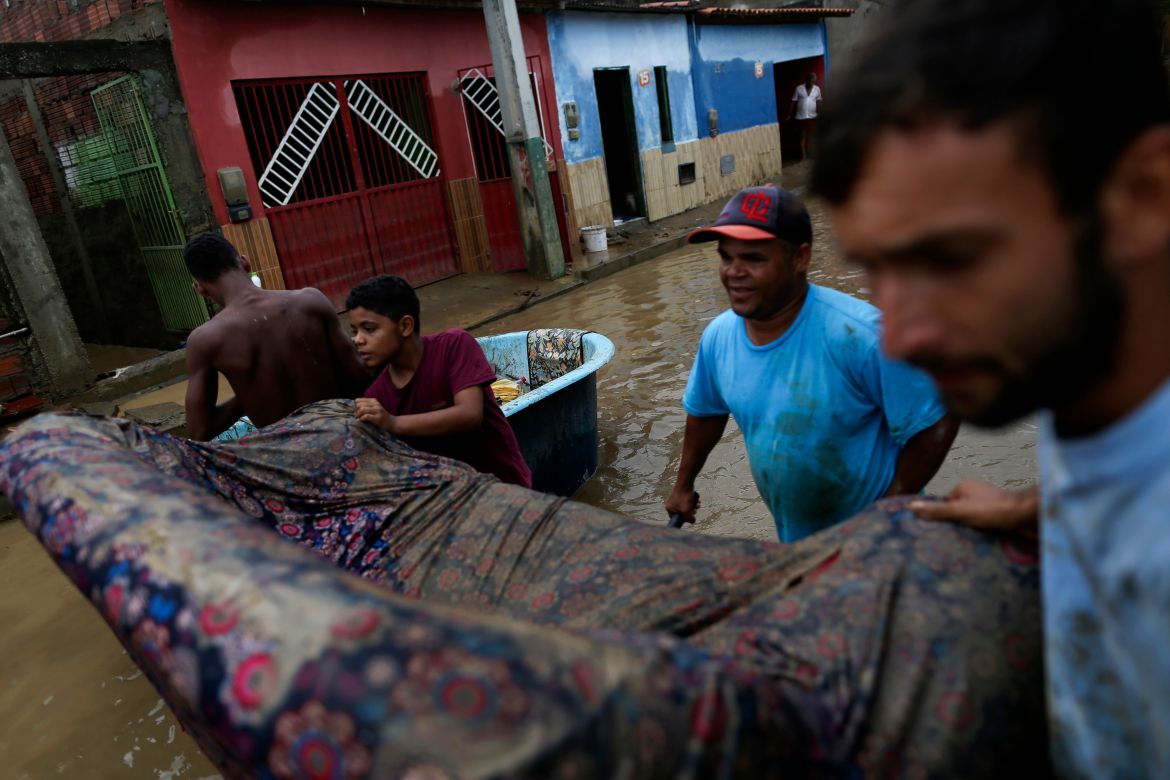 Residents clean out their flooded homes in Bahia state, Brazil