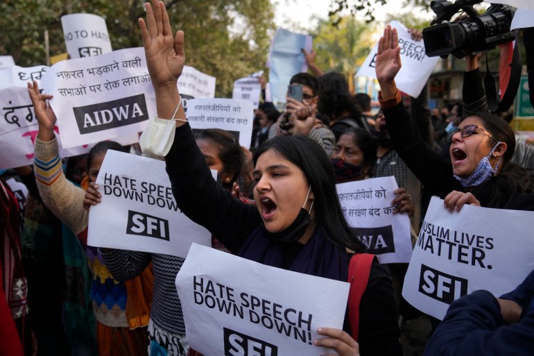 Female activists shout slogans against hate speech while holding signs that read "down with hate speech" and "Muslim lives matter" in New Delhi