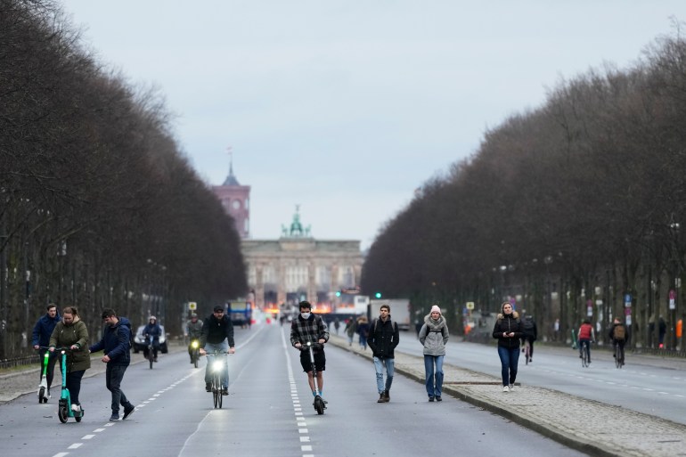 A few people walk on the boulevard 'Strasse des 17. Juni' in front of the Brandenburg Gate Berlin, Germany