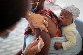 A healthcare worker administers the coronavirus disease (COVID-19) vaccine to a woman, amidst spread of the Omicron variant in Johannesburg, South Africa [File: Sumaya Hisham/Reuters]