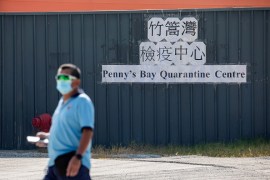 Man wearing mask walks in front of quarantine centre in Hong Kong