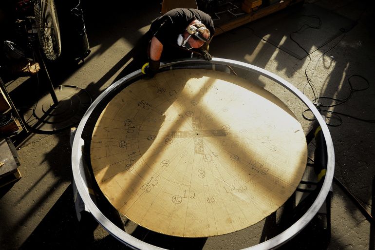 A worker uses a buffer to smooth the outer edge of a clock at a production facility in Cincinnatti, Ohio