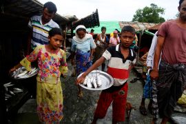 Mostly Muslim Rohingya men and women in an open air market at a camp for displaced people in Sittwe