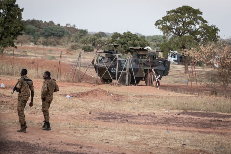 Burkina Faso army officers patrol near a French armoured vehicle parked in Kaya, capital of Burkina Faso's north-central region, after people protest to oppose the passage of a large French army logistics convoy in transit to neighboring Niger, on November 20, 2021. (Photo by OLYMPIA DE MAISMONT / AFP)