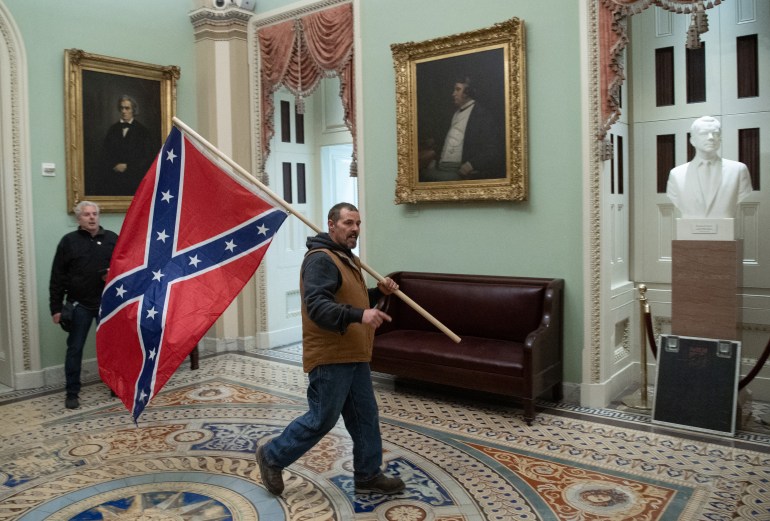 Apoiante de Trump carrega uma bandeira da Confederação na Rotunda do Capitólio dos EUA