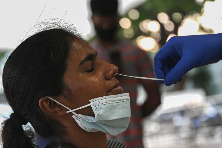 A woman is getting a nasal swab to test for the coronavirus disease in Chennai, India