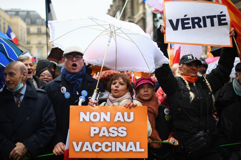 Demonstrator holds a banner reading "No to health pass" and "Truth" during a protest against the health pass in Paris, France