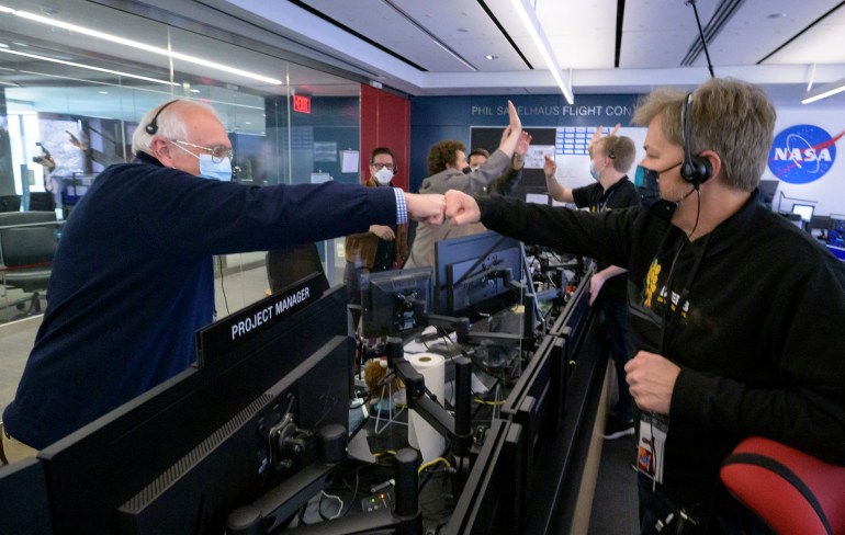 Two NASA scientists fist bump each other at the Space Telescope Science Institute in Baltimore, Maryland