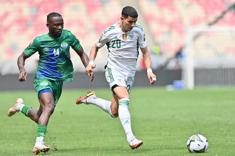Sierra Leone's forward Mohamed Buya Turay (L) fights for the ball with Algeria's defender Youcef Attal