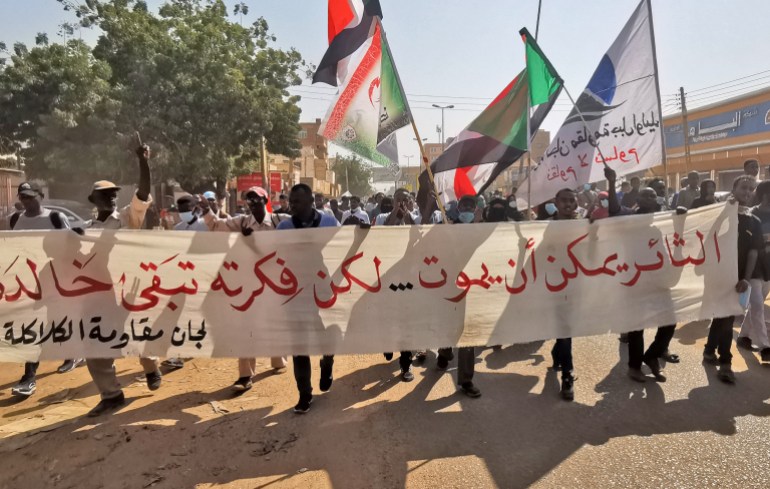 Sudanese anti-coup protesters hold a banner during a demonstration in Khartoum