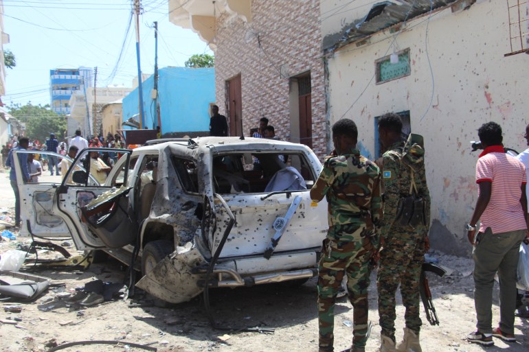 Government soldiers look at the scene of suicide bomb attack in Mogadishu