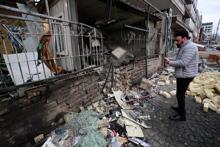 An Iraqi man checks the scene of an explosion outside the Kurdish Cihan Bank in the Karrada district of Iraq