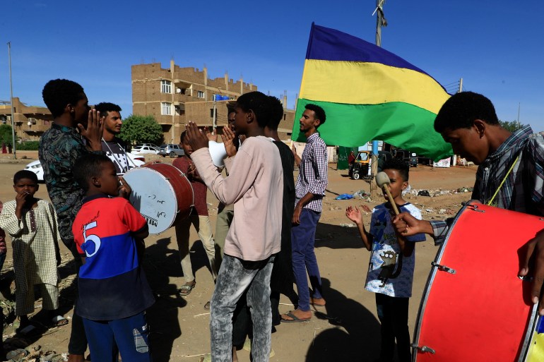 Sudanese youths beat drums and chant slogans in Khartoum