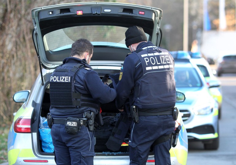 Police officers put their gear back into their car on the compound of the University of Heidelberg