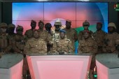 Captain Sidsore Kader Ouedraogo, centre, spokesman for the military government, with uniformed soldiers announces that they have taken power in Burkina Faso [Radio Television du Burkina (RTB)/Handout via AFP]