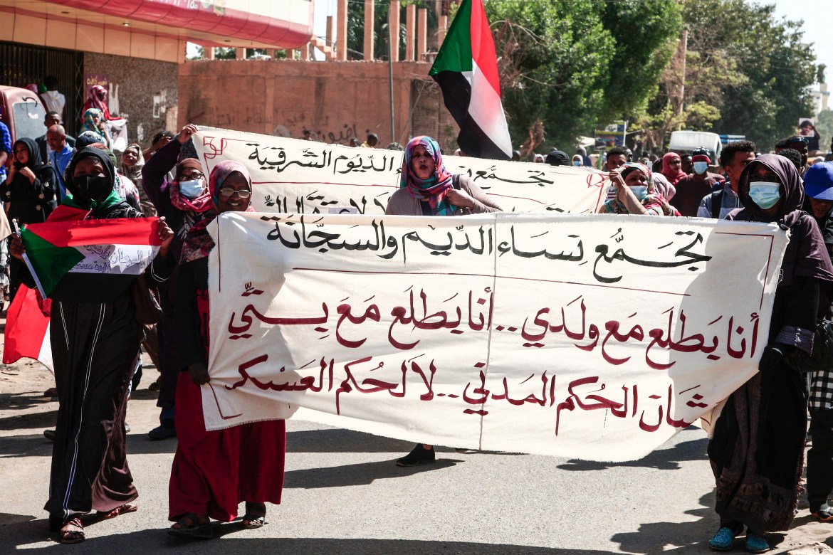 Sudanese women carry banners as they take part in a rally to protest against last year's military coup, in the capital Khartoum, on January 30, 2022.