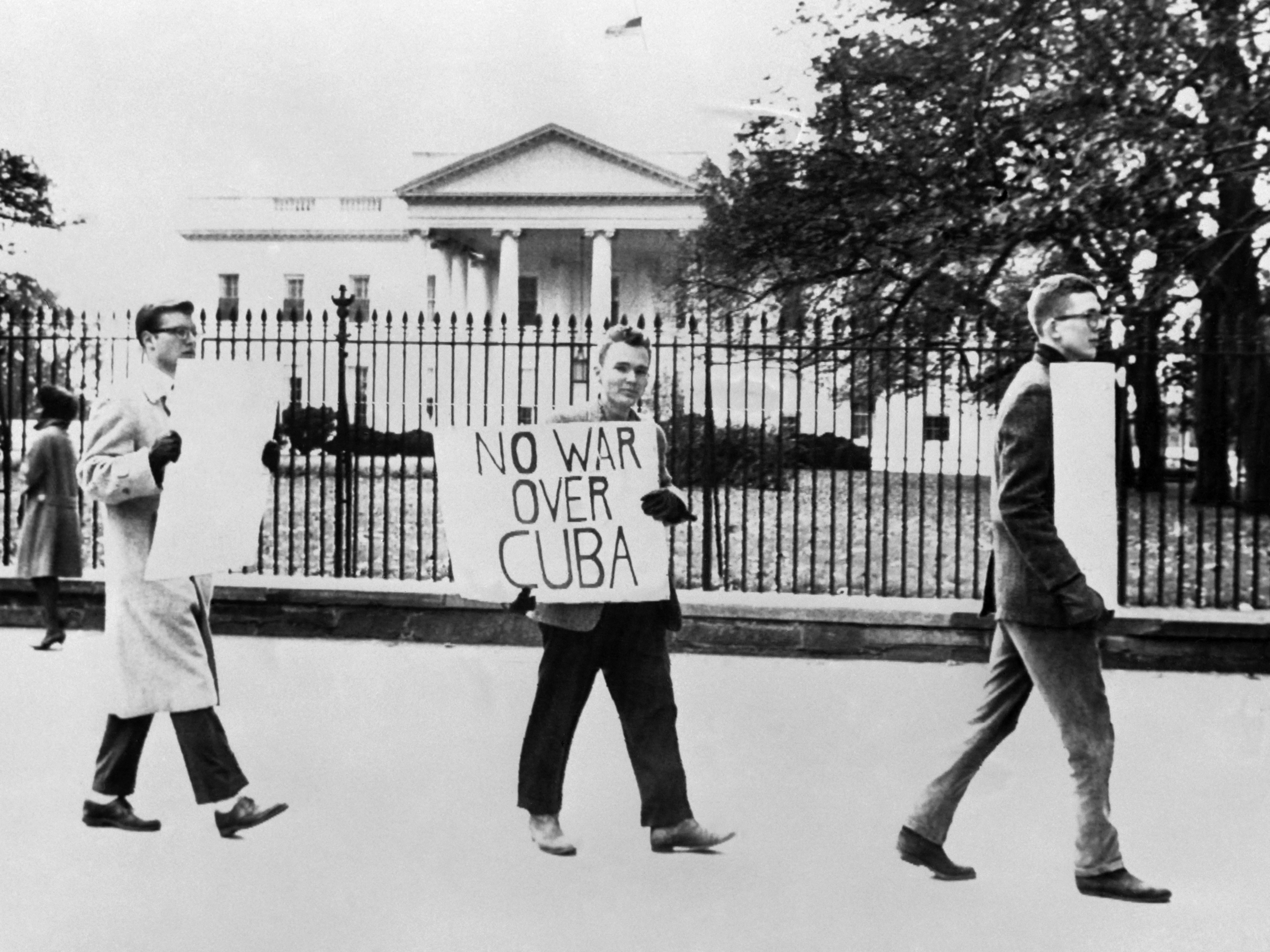 Pessoas protestam contra a guerra em 27 de outubro de 1962 em frente à Casa Branca em Washington, DC, durante a crise dos mísseis cubanos.  Em 22 de outubro de 1962, o presidente Kennedy informou ao povo americano da presença de locais de mísseis em Cuba.  As tensões aumentaram e o mundo se perguntou se poderia haver uma solução pacífica para a crise, até 20 de novembro de 1962, quando bombardeiros russos deixaram Cuba e Kennedy levantou o bloqueio naval.  (Foto: AFP)