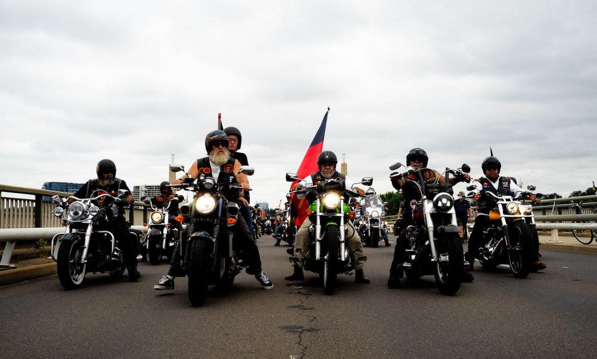 Members of four Indigenous motorcycle clubs riding on a road in Canberra, Australia.