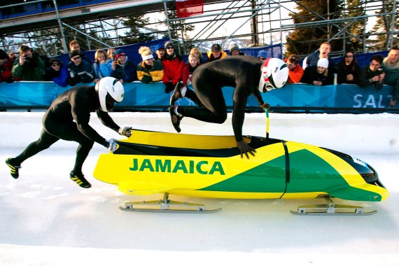 Lascelles Oneil Brown (L) and Winston Alexander Watt of the Jamaica-1 team leap into their sled at the start of heat three of the two-man bobsleigh competition at the Salt Lake 2002 Winter Olympic Games, February 17, 2002 in Park City