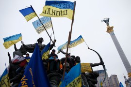 Pro-European integration protesters stand on a statue with Ukranian flags during a rally in Independence Square in Kiev December 15, 2013.
