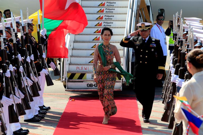 Aung San Suu Kyi walks on a red carpet and reviews honour guards upon arrival at the Manila International airport in the Philippines.
