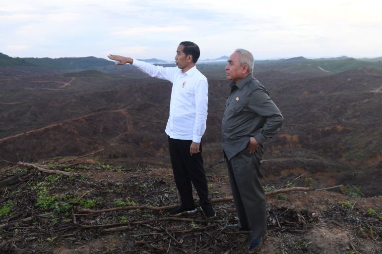 Indonesian President Joko Widodo gestures as Governor of East Kalimantan stands during their visit to an area, planned to be the location of Indonesia's new capital at East Kalimantan province, Indonesia December 17, 2019