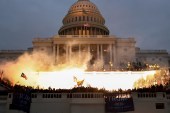 An explosion caused by a police munition is seen while supporters of US President Donald Trump riot in front of the US Capitol Building in Washington on January 6, 2021 [File: Reuters/Leah Millis]