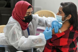 A woman receives a dose of a COVID-19 vaccine at St. Paul's Church in Abu Dhabi