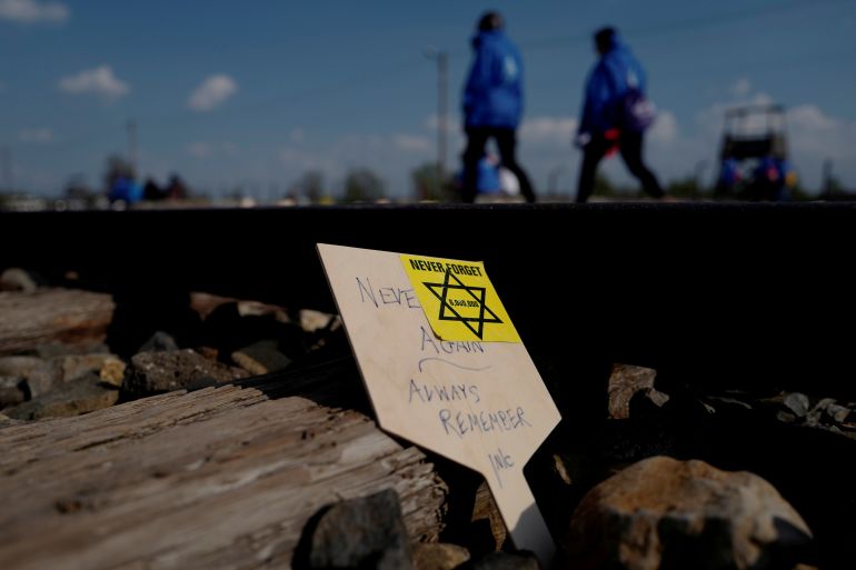 Participants pass a card with words 'Never again, always remember' during the annual "March of the Living" to commemorate the Holocaust at the former Nazi concentration camp Auschwitz