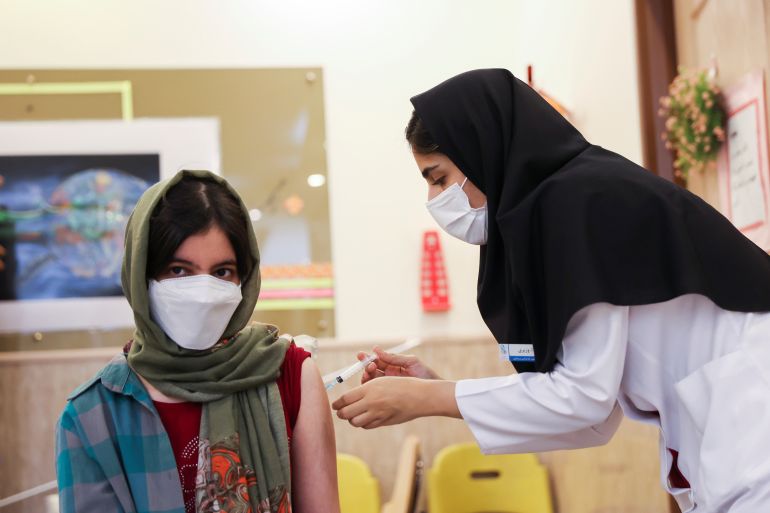 An Iranian teenager receives a dose of a vaccine against the coronavirus disease (COVID-19) at a school in Tehran, Iran October 7, 2021