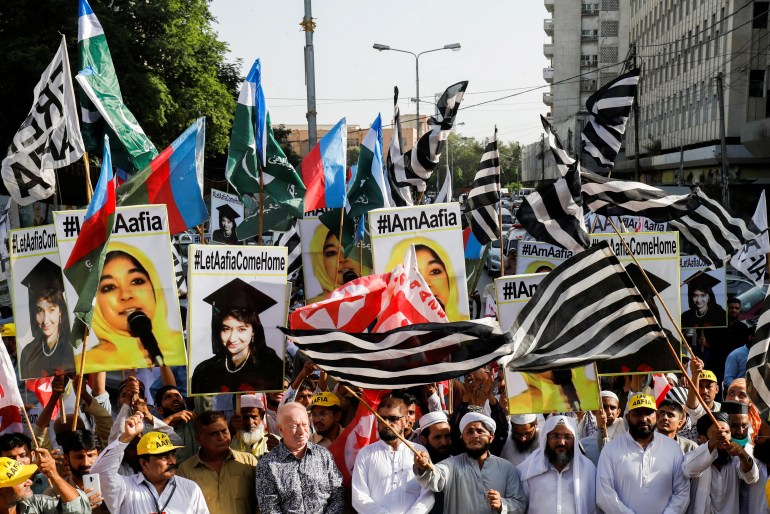 People carry flags and signs demanding release of Aafia Siddiqui
