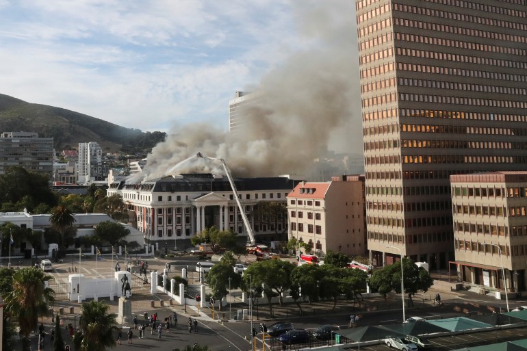 Firefighters work at the parliament as the fire flared up again, in Cape Town, South Africa,