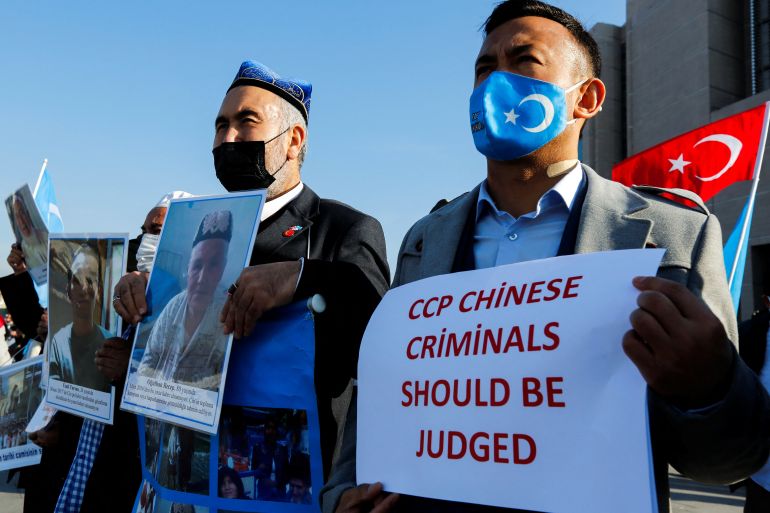 Ethnic Uighur men hold up protest signs outside of the courthouse in Istanbul, Turkey with one sign reading: 'CCP Chinese officials should be judged'