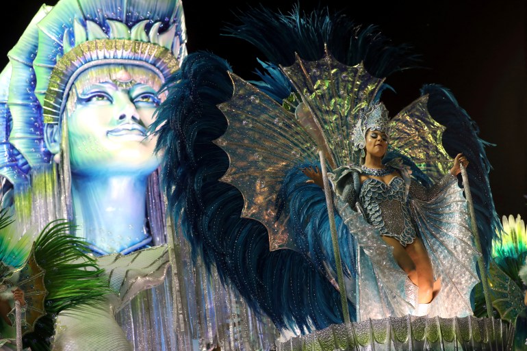 A woman in a sparkling pale blue costume dances the samba on a float at the 2020 Rio Carnival