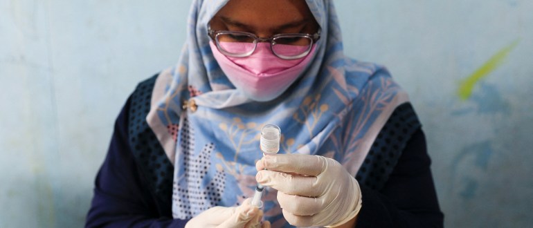 A healthcare worker prepares a dose of China’s Sinovac Biotech vaccine against the coronavirus disease (COVID-19) during a mass vaccination program for children aged 6-11 years, as the Omicron variant continues to spread in Jakarta, Indonesia, January 5, 2022. REUTERS/Willy Kurniawan