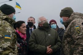 High Representative of the European Union for Foreign Affairs Josep Borrell talks to group of Ukrainians outside with a Ukrainian flag in the background