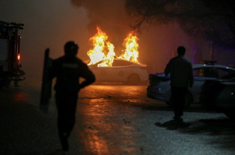 A police car burns during a protest in Almaty, Kazakhstan