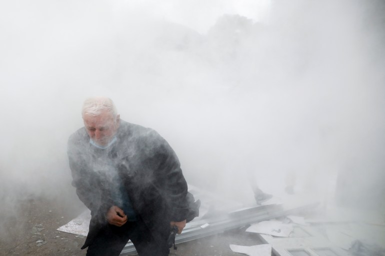 A man reacts as protesters demonstrate outside the headquarters of the Democratic Party in Tirana