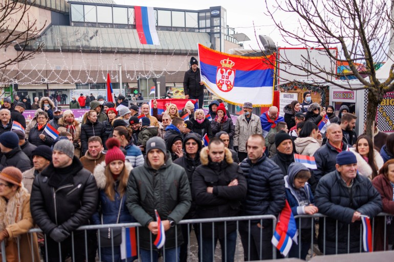 People hold Serbian and Republika Srpska flags during parade celebrations to mark their Serb Republic's national holiday