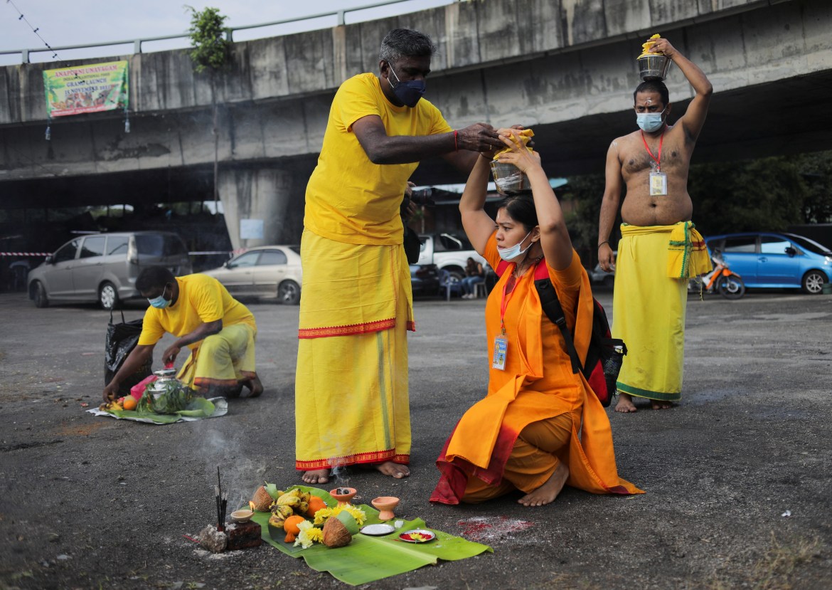 Hindu devotees preparing a port of milk to carry on their pilgrimage to Sri Subramaniar Swamy Temple during celebrations of Thaipusam, which resumed with tight health protocols after a one-year hiatus due to the coronavirus disease (COVID-19) pandemic, at Batu Caves, Malaysia, January 18, 2022. REUTERS/Hasnoor Hussain