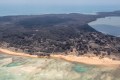 An aerial photo shows shows heavy ash fall over Nomuka in Tonga, with the island turned a dirty brown instead of its usual lush green