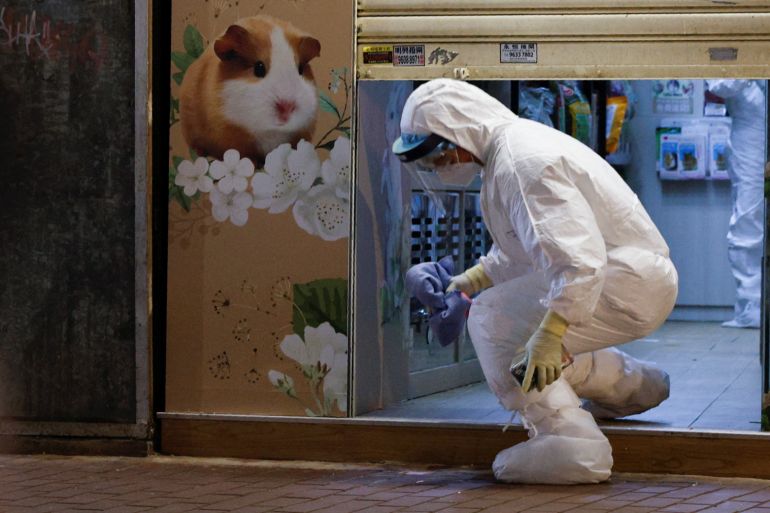 A wildlife officer with personal protective equipment leaves a temporarily closed pet shop in Hong Kong