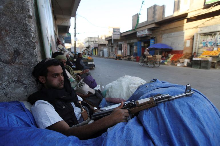 A Houthi fighter sits behind sandbags near a checkpoint in Sanaa