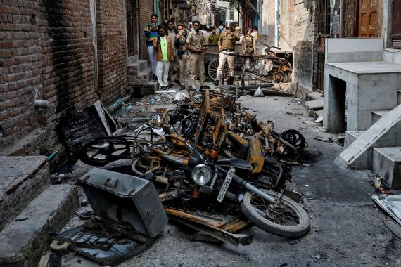 Police photograph burnt-out properties owned by Muslims in a riot-affected area in Delhi
