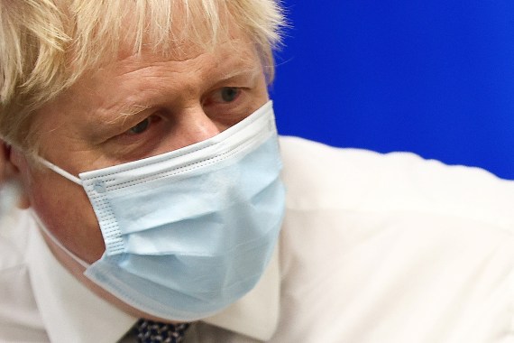 Close up picture of Boris Johnson in a surgical mask and white shirt visiting a hospital