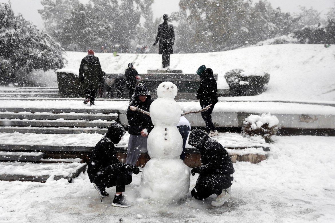 Youth make a snowman during heavy snowfall in Athens, Greece